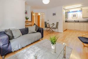 a living room with a couch and a kitchen at Luxury Modern 1 Bedroom Apartment In Birmingham City Centre-Free Parking in Birmingham