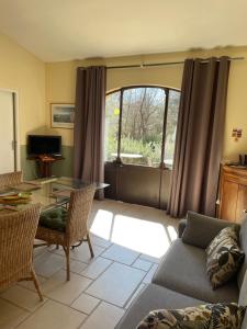 a living room with a couch and a table at Le Bois De La Cour in Roussillon