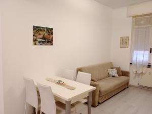 ein Wohnzimmer mit einem weißen Tisch und einem Sofa in der Unterkunft Casa Mariuccia in Santa Margherita Ligure