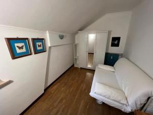 un soggiorno con divano bianco in una camera di Ideale per due famiglie. Comodo a centro e piste a Bardonecchia