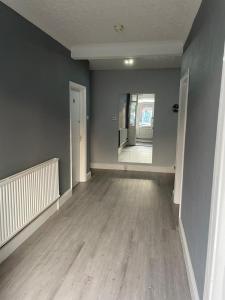 an empty room with wooden floors and a hallway at 2 Bedroom Ground Floor Holiday Apartment Skegness in Lincolnshire