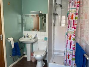 a bathroom with a toilet and a sink and a shower at 2 Bedroom Ground Floor Holiday Apartment Skegness in Lincolnshire