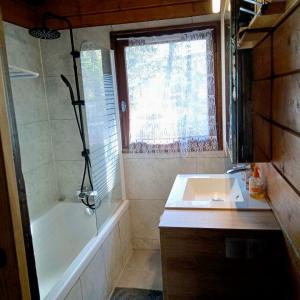 La salle de bains est pourvue d'une baignoire, d'un lavabo et d'une douche. dans l'établissement Chalet paisible 6 personnes, à Uvernet