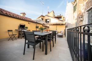 a patio with a table and chairs on a balcony at Casa del Carro 2 Grand Terrace Apartment in Venice