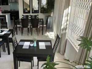 a dining room with tables and chairs on a balcony at Amani Luxe Villa in Amsterdamhoek