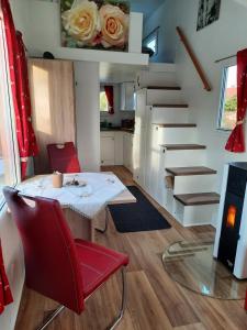 a small dining room with a table and red chairs at Tiny Haus am Motzener See in Motzen