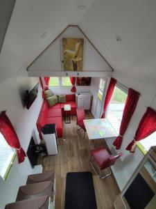 einen Blick über ein Wohnzimmer mit einem roten Sofa in der Unterkunft Tiny Haus am Motzener See in Motzen