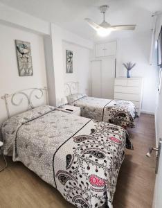 een slaapkamer met 2 bedden in een kamer bij Infantes Beach Apartment in Torre del Mar