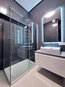 La salle de bains est pourvue d'une douche en verre et d'un lavabo. dans l'établissement Apartbaltic - Platan Tower, à Świnoujście