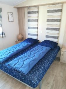 two beds in a bedroom with blue pillows at CS 71 - Vakantiepark Callassande in Callantsoog