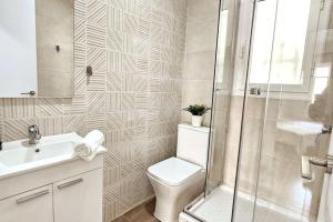 a bathroom with a toilet and a sink and a shower at Apartamento con Playa del Arenal a los pies in Platja de l'Arenal +17 photos