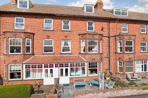 a large brick building with tables and chairs in front of it at White Rose Guest House in Filey