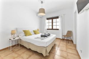 a white bedroom with a bed and a window at Villa 22 in Tías +49 photos