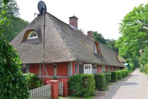 Casa roja y blanca con techo de paja en Wohnungen unter Reet, en Krems Zwei