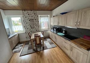eine Küche mit Holzschränken sowie einem Tisch und Stühlen in der Unterkunft Haus Medaillon in Hamm