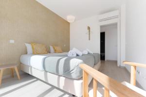 a bedroom with a large white bed with yellow pillows at Villa Hobie Cat in Sagres +29 photos