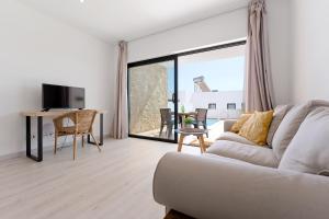 a living room with a couch and a large window at Villa Hobie Cat in Sagres