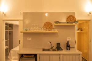 a kitchen with a sink and shelves with dishes at Acrus Villa Santorini with Heated pool in Karterados