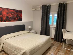 a bedroom with a bed and a painting on the wall at VillaGiò B&B in Frascati
