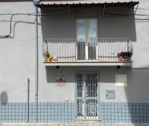 a white building with a balcony and a door at Alloggio Pulcinella in Acerra