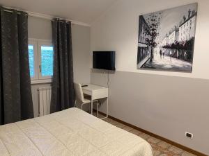 Schlafzimmer mit einem Bett, einem Schreibtisch und einem TV in der Unterkunft VillaGiò B&B in Frascati