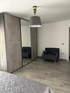 1 dormitorio con espejo, sofá y cama en Alloggio Pulcinella, en Acerra