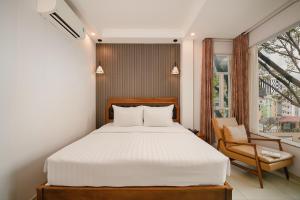 a bedroom with a bed and a chair and a window at Tuong Vy Ben Thanh Hotel - 40 Bui Thi Xuan in Ho Chi Minh City