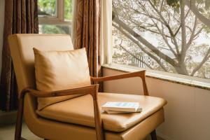 a book sitting on a chair in front of a window at Tuong Vy Ben Thanh Hotel - 40 Bui Thi Xuan in Ho Chi Minh City