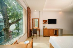 a bedroom with a bed and a window and a desk at Tuong Vy Ben Thanh Hotel - 40 Bui Thi Xuan in Ho Chi Minh City