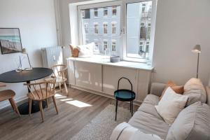 ein Wohnzimmer mit einem Sofa, einem Tisch und einem Fenster in der Unterkunft City-Center App ZENTRAL, 24-7 Check-in in Kiel