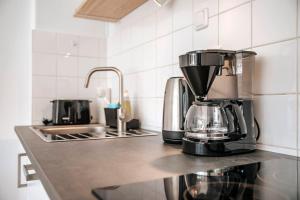 eine Kaffeemaschine auf einer Theke in einer Küche in der Unterkunft City-Center App ZENTRAL, 24-7 Check-in in Kiel
