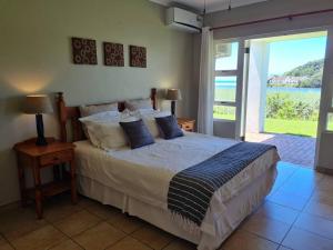 a bedroom with a bed with a view of the water at Villa Arroyo, Estuary Estate, Port Edward in Port Edward