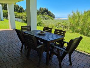 a wooden table and chairs on a patio at Villa Arroyo, Estuary Estate, Port Edward in Port Edward