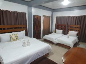 1 dormitorio con 2 camas con sábanas blancas en Kalis Viewpoint Lodge Coron, en Corón