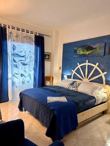 a bedroom with a large bed with a blue wall at Casa del Palombaro in Le Grazie