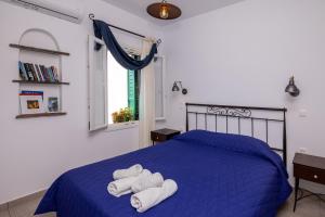 una camera da letto con un letto blu e asciugamani di Astrokaktos a Skaládhos