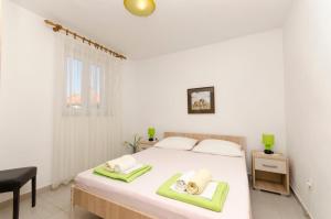 a bedroom with a bed with two towels on it at Apartments Banic in Postira