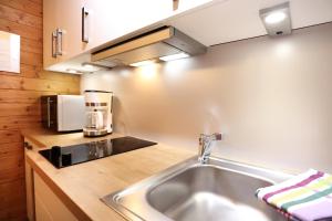 eine Küche mit einer Spüle und einer Mikrowelle in der Unterkunft Beim Gschdoaga in Mittenwald