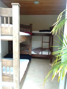 a room with three bunk beds in a house at Hostal Hilltop Salento in Salento