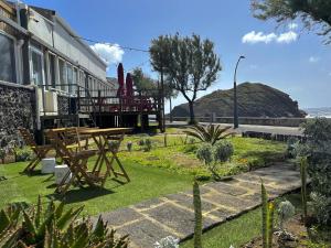 eine Terrasse mit einem Picknicktisch und Meerblick in der Unterkunft Cantinho do Ilhéu in Ponta Delgada