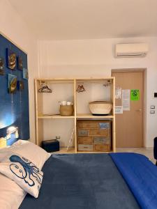 レ・グラツィエにあるCasa del Palombaroのベッドルーム1室(ベッド1台付)、木製キャビネットが備わります。