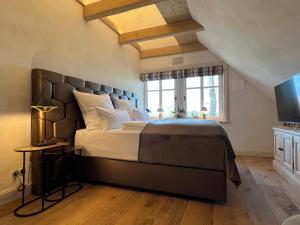 Un dormitorio con una cama grande y una ventana en Landhüüs Oeverdiek - Luxus am Golfplatz, en Timmendorfer Strand
