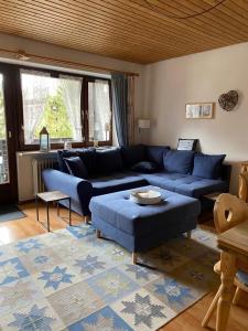 uma sala de estar com um sofá azul e uma mesa em Ferienwohnung Mattenklotz em Sachrang