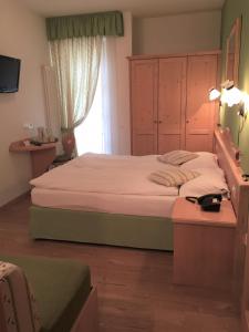 um quarto com uma cama grande e uma janela em Affittacamere Sissi em Commezzadura