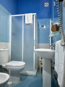 een blauwe badkamer met een douche, een toilet en een wastafel bij Casa del Palombaro in Le Grazie