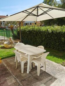 a white table and chairs under an umbrella at N194 - Numana, ampio trilocale con giardino in Numana