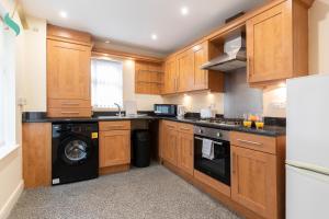 a kitchen with wooden cabinets and a washer and dryer at 53 The Ladle TSAC in Middlesbrough