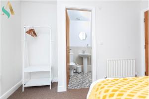 a bedroom with a yellow bed and a bathroom at 53 The Ladle TSAC in Middlesbrough