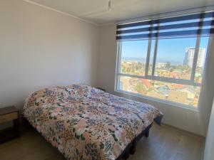 Un dormitorio con una cama y una ventana grande. en departamento nuevo amoblado sin uso, en Viña del Mar