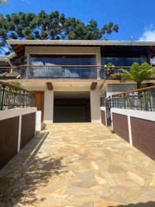 a house with a garage and a balcony at Suítes Andorinhas in Monte Verde